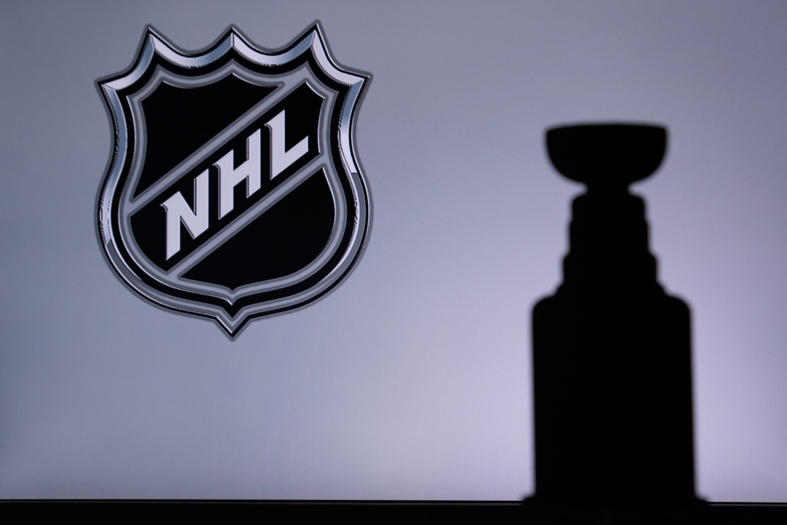 TORONTO, CANADA, 17. JULY: National Hockey LeagueLogo of NHL club on the screen. Stenley Cup Trophy Silhouette.