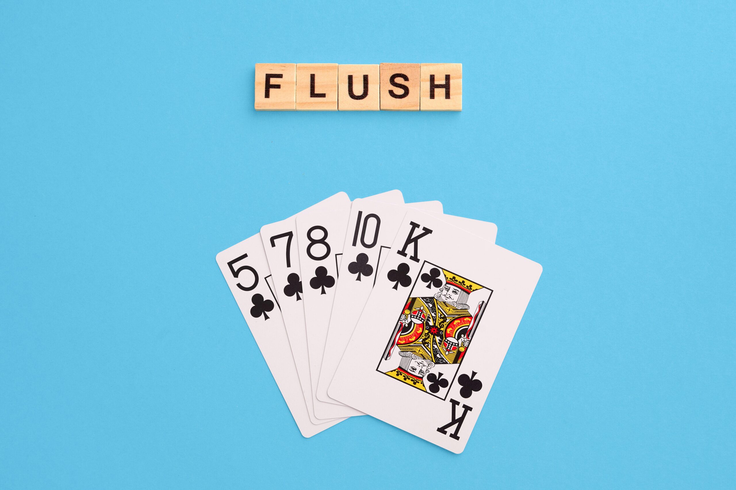 2J53TB3 Flush combination. Poker Playing Cards on blue background with wooden blocks. Flatlay, copy space, concept