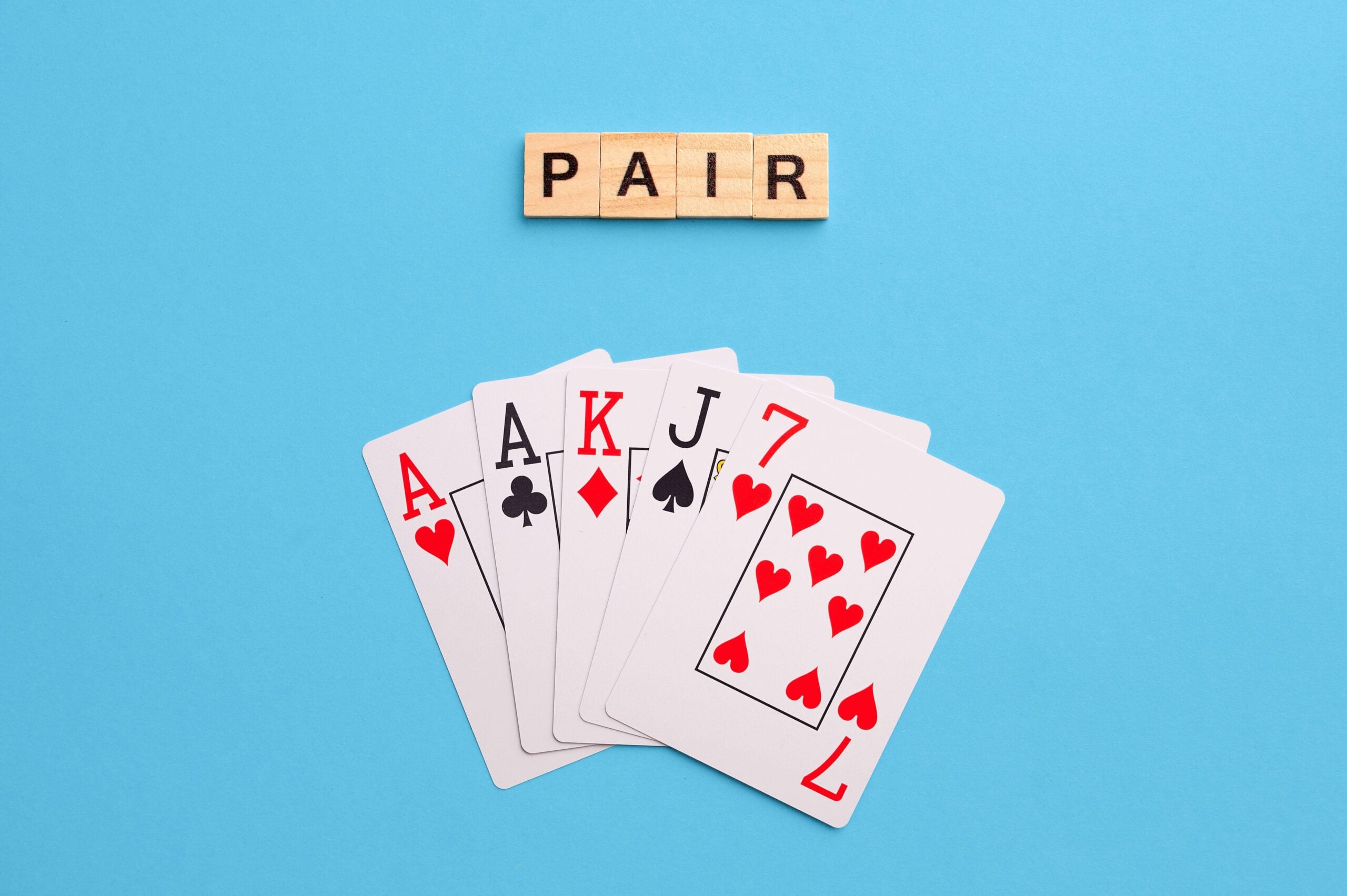 2J53TEX Pair combination. Poker Playing Cards on blue background with wooden blocks. Flatlay, copy space, concept