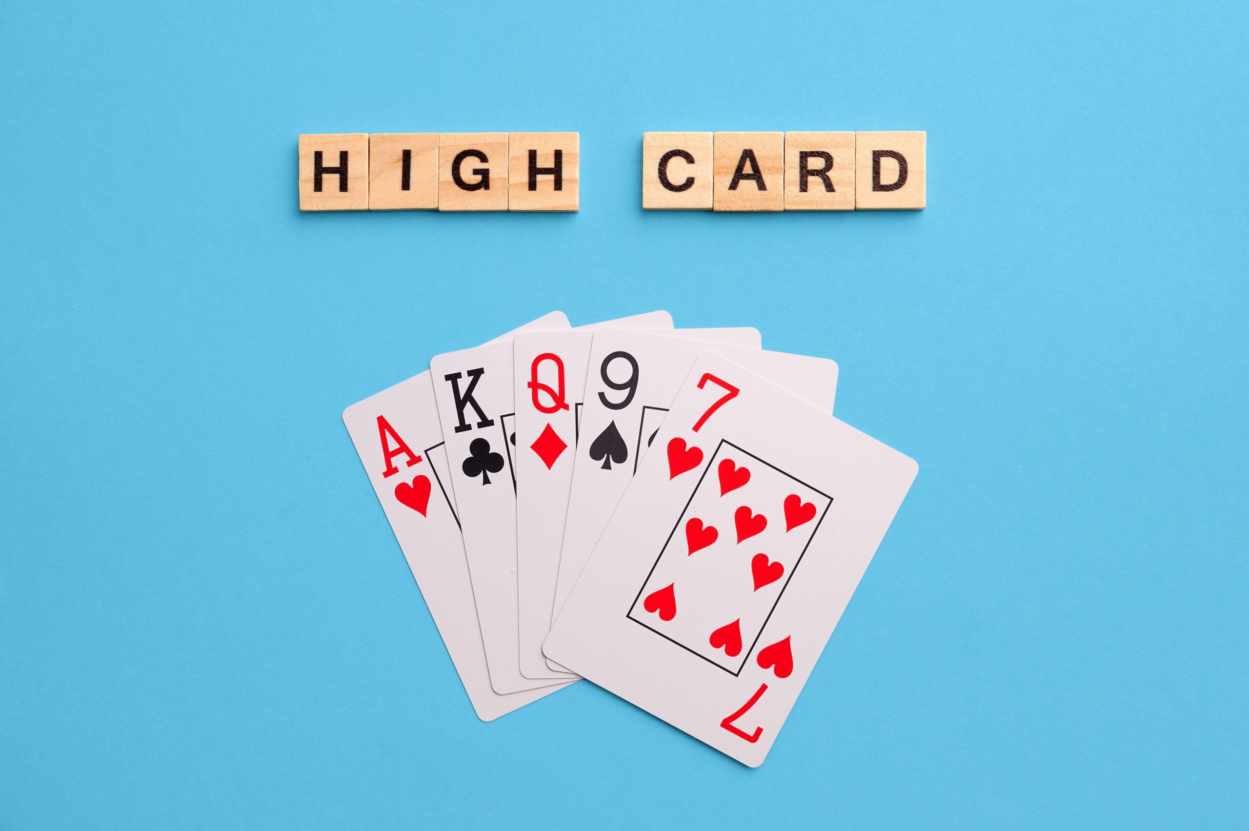 2J53THG High card combination. Poker Playing Cards on blue background with wooden blocks. Flatlay, copy space, concept