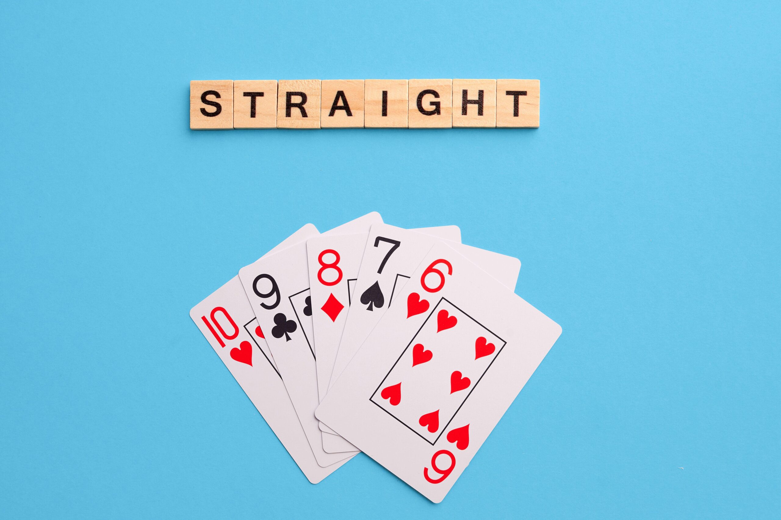 2J53TM6 Straight combination. Poker Playing Cards on blue background with wooden blocks. Flatlay, copy space, concept