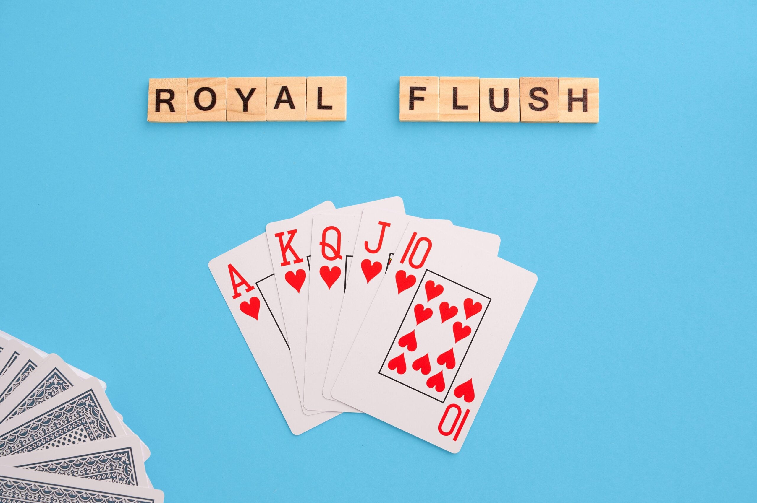 2J53TT5 Royal flush combination. Poker Playing Cards on blue background with wooden blocks. Flatlay, copy space, concept